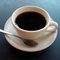 black-coffee-cup-saucer-white-silver-spoon-grey-blue-surface-photo.jpg